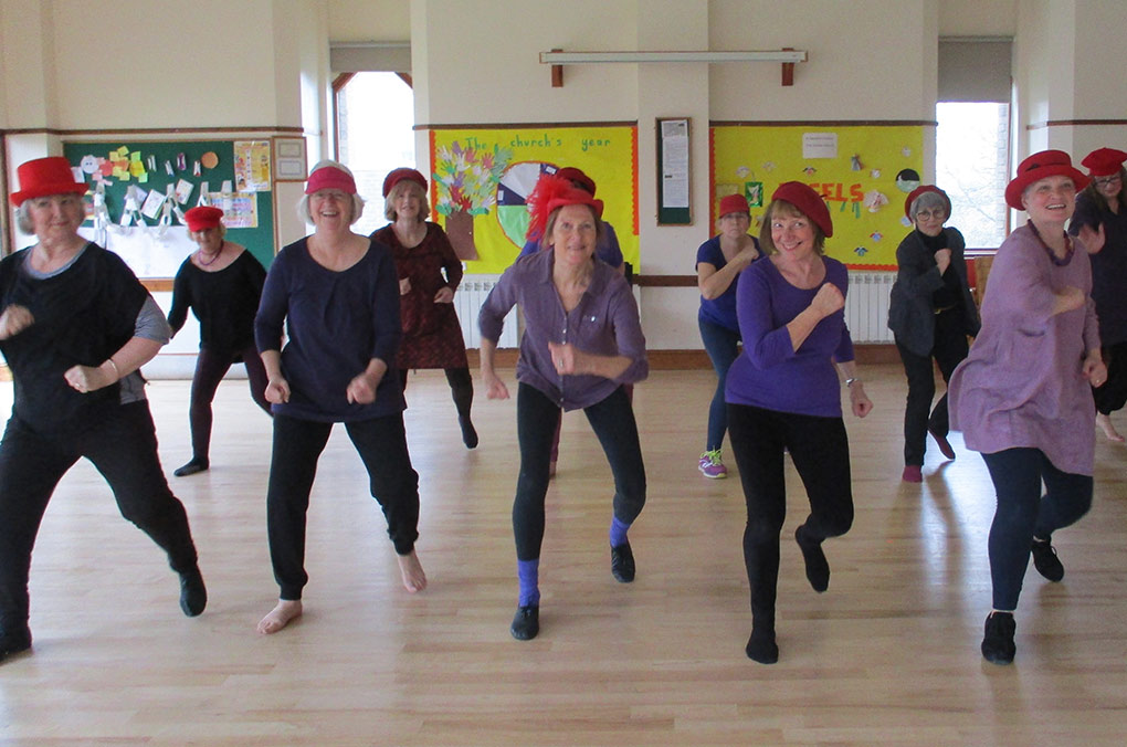 women performing with frames around their necks.